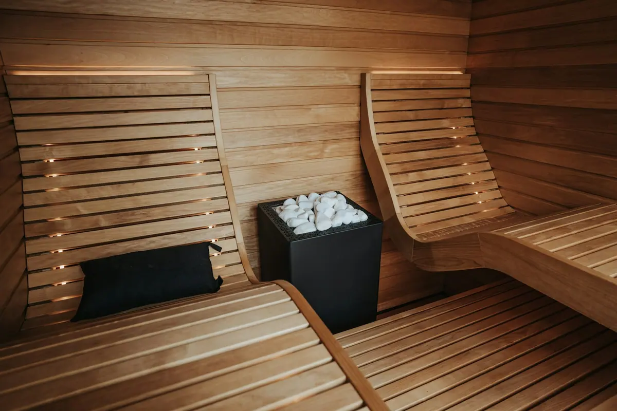 Sauna de madera con bancos y piedras