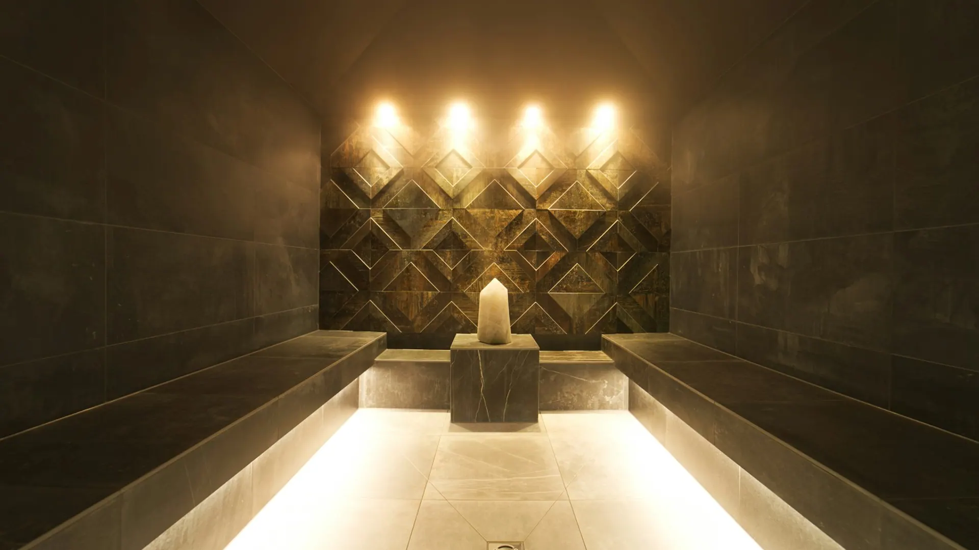 Sala de vapor con iluminación cálida y un cristal sobre un pedestal
